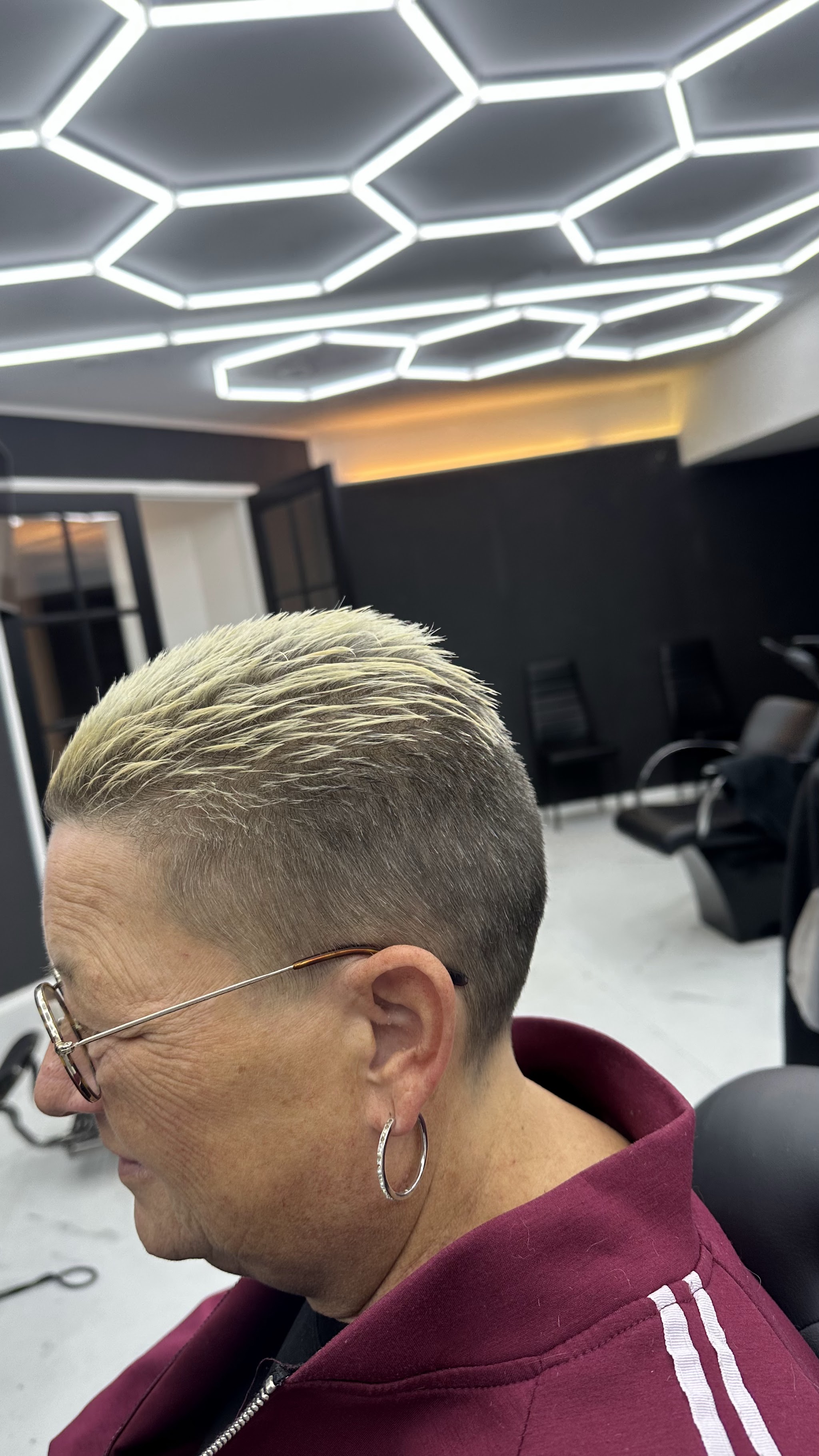 Een kort, blond en strak geknipt kapsel, van opzij gezien in de zaak